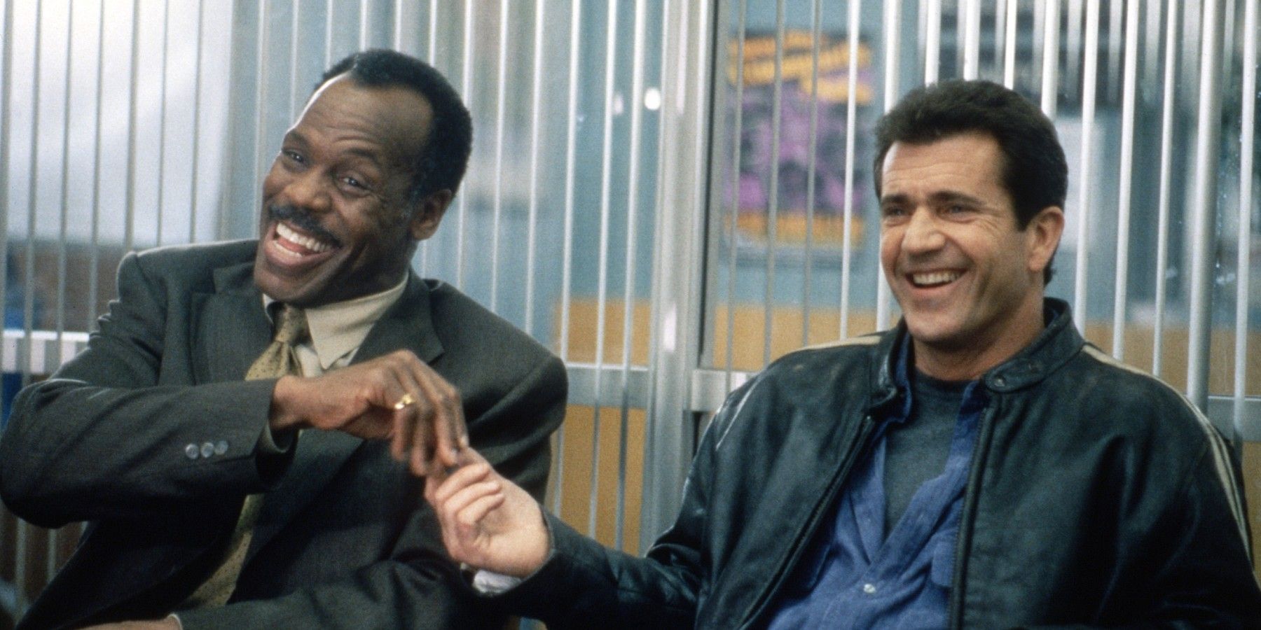 Danny Glover and Mel Gibson fist bump in their superior's office in Lethal Weapon 3