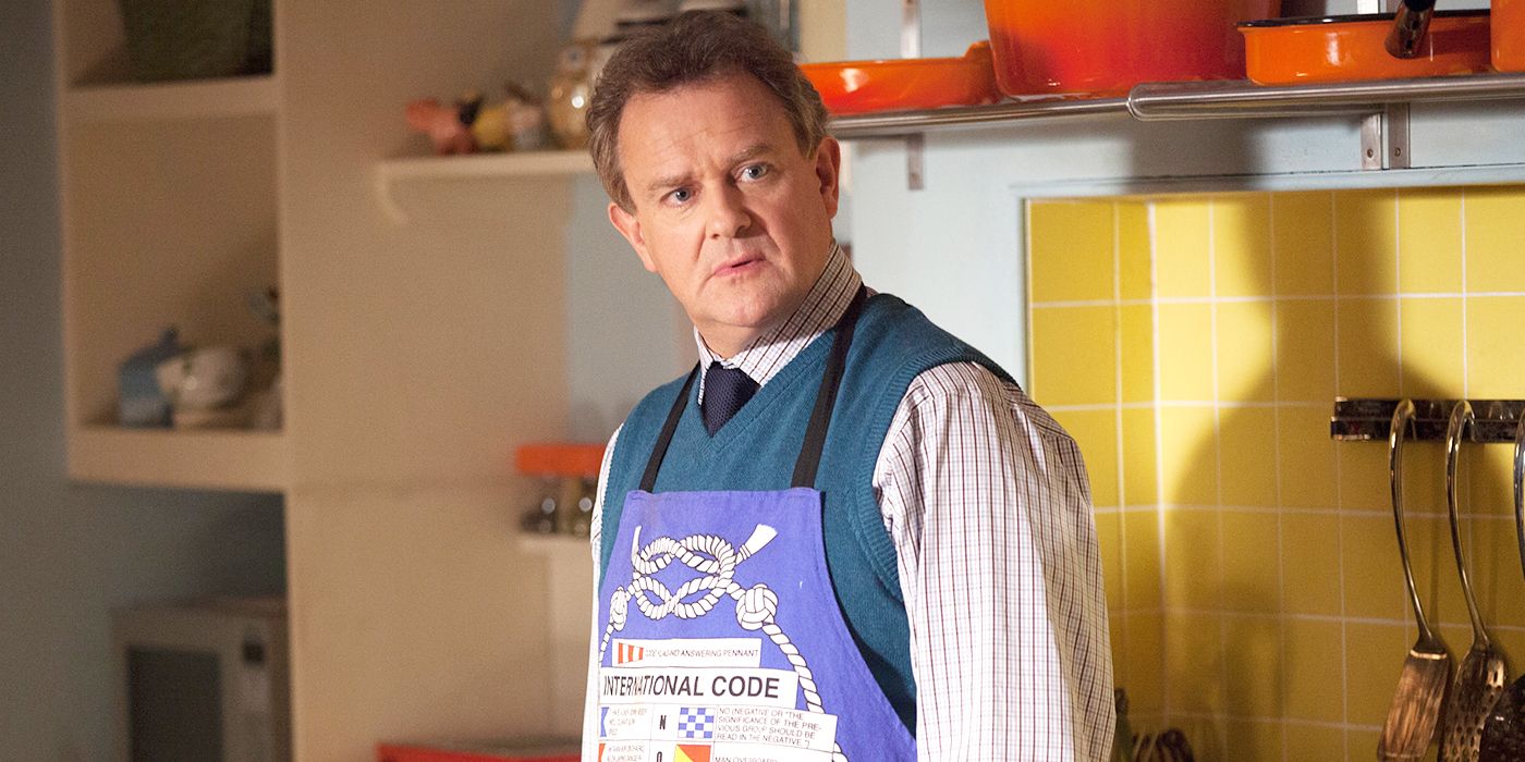 Hugh Bonneville in an apron as Mr. Brown in 'Paddington'