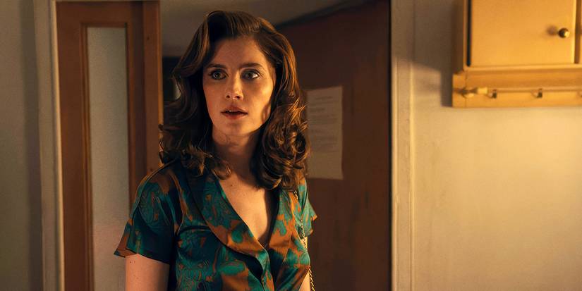 Vic Michaelis as Cheryl standing in a room and looking surprised in Ponies