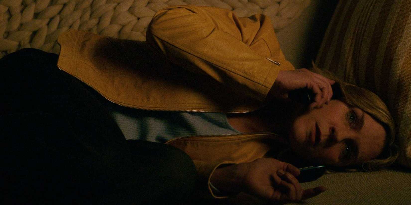 carol-lying-sideways-on-her-couch-holding-her-phone-to-her-ear