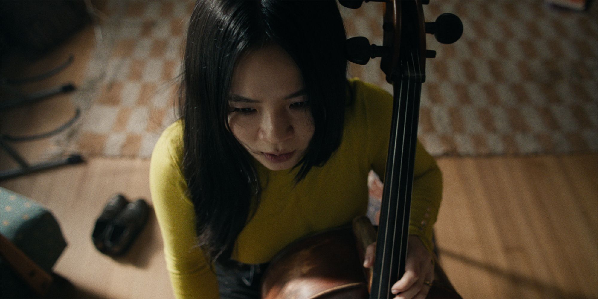 Kelly Marie Tran as Emily playing the cello in Rock Springs