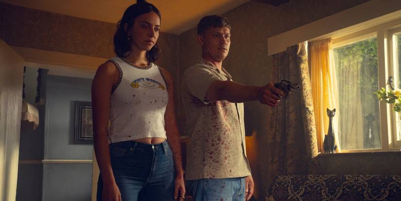 Maeve Courtier-Llilley and Jon Pointing as Dee Dee and Ash holding a gun and looking at something off-screen on 'Run Away.'