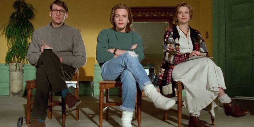 Two men and a woman with their legs crossed in Shallow Grave