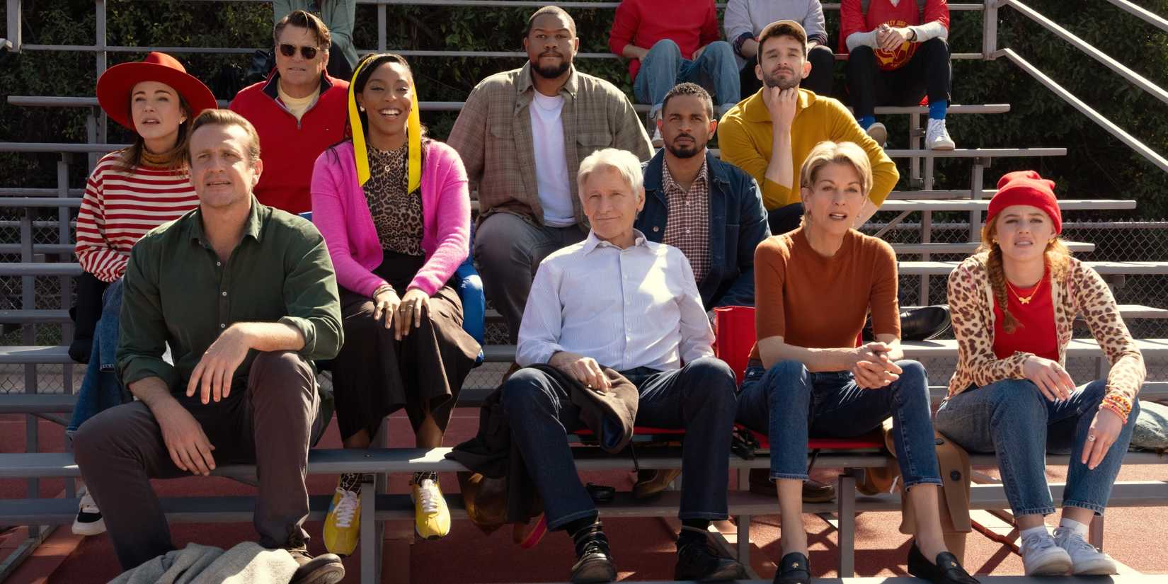Jason Segel sitting on bleachers with Harrison Ford, Jessica Williams, and the cast of Shrinking Season 3