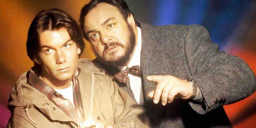 Quinn and Arturo standing close together and looking at something offscreen in Sliders