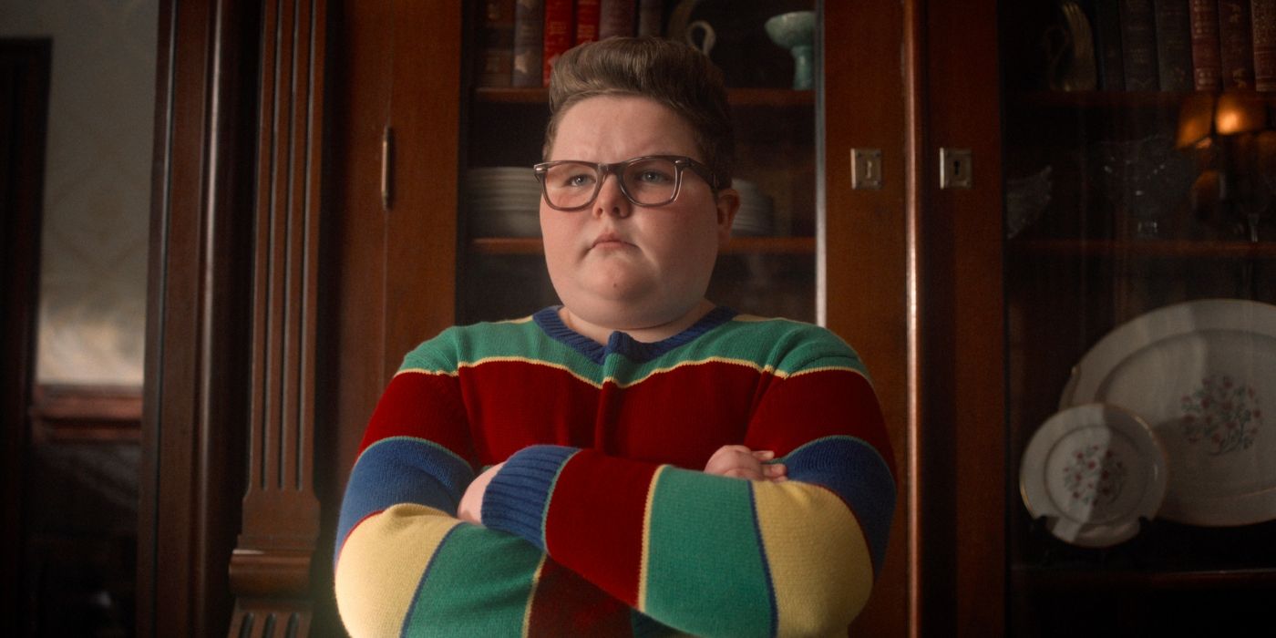 Jake Connelly as Derek Turnbow in a colorful striped sweater with his arms crossed in 'Stranger Things.'