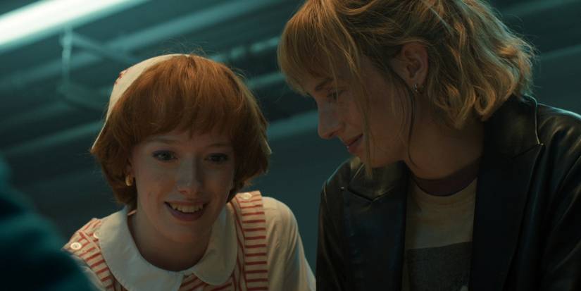 Amybeth McNulty as Vickie Dunne and Maya Hawke as Robin Buckley smiling in 'Stranger Things.'
