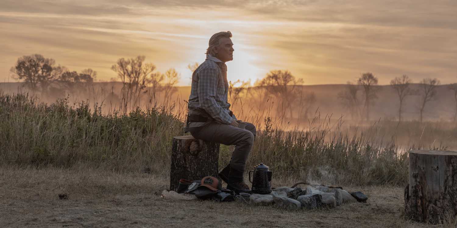 Kurt Russell as Preston Clyburn sitting beside a campfire on 'The Madison'