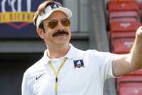 Jason Sudeikis smiling and pointing as Ted in Ted Lasso Season 4