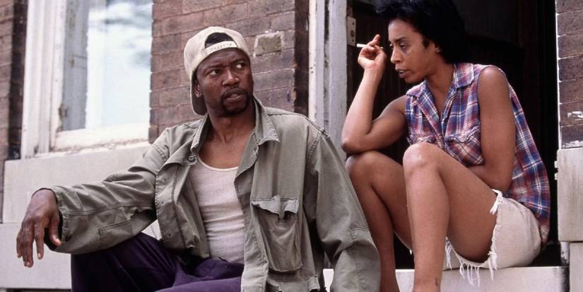 Two people sitting on concrete steps and talking in The Corner.