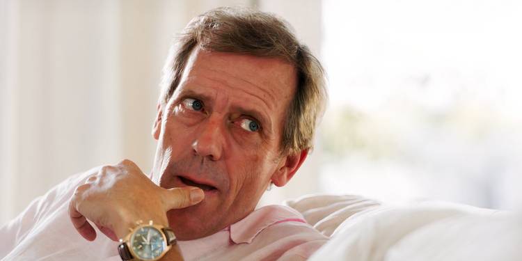 Roper looking thoughtful with his thumb resting on his chin in The Night Manager Season 1.