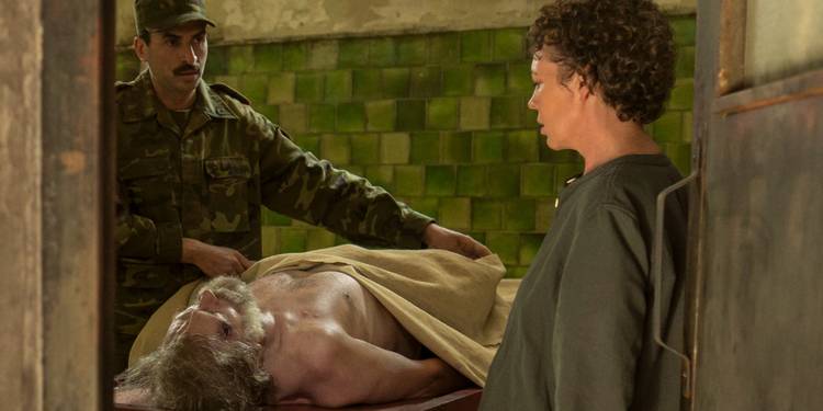 Angela Burr staring down at Richard Roper's body as it lies on a slab in The Night Manager Season 2 Episode 1