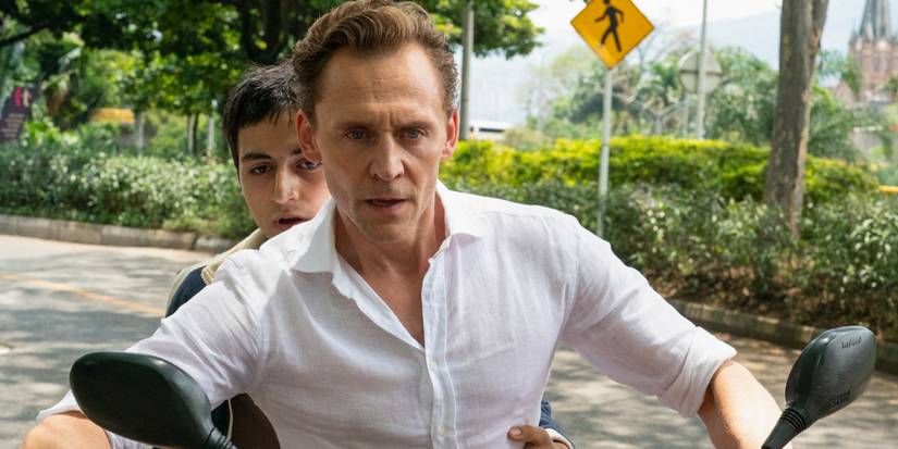 Jonathan Pine driving a motorcycle with a younger man sitting behind him in The Night Manager Season 2 Episode 4