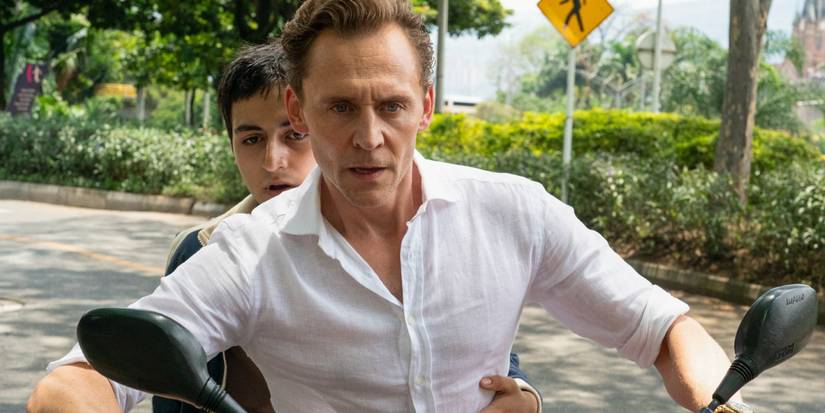 Jonathan Pine riding a motorcyle with a teen boy sitting behind him in The Night Manager Season 2