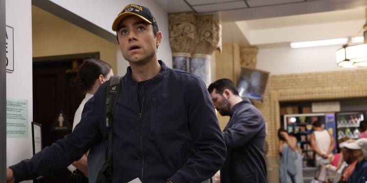 Dr. Langdon (Patrick Ball) wearing a hat and looking nervous in 'The Pitt'