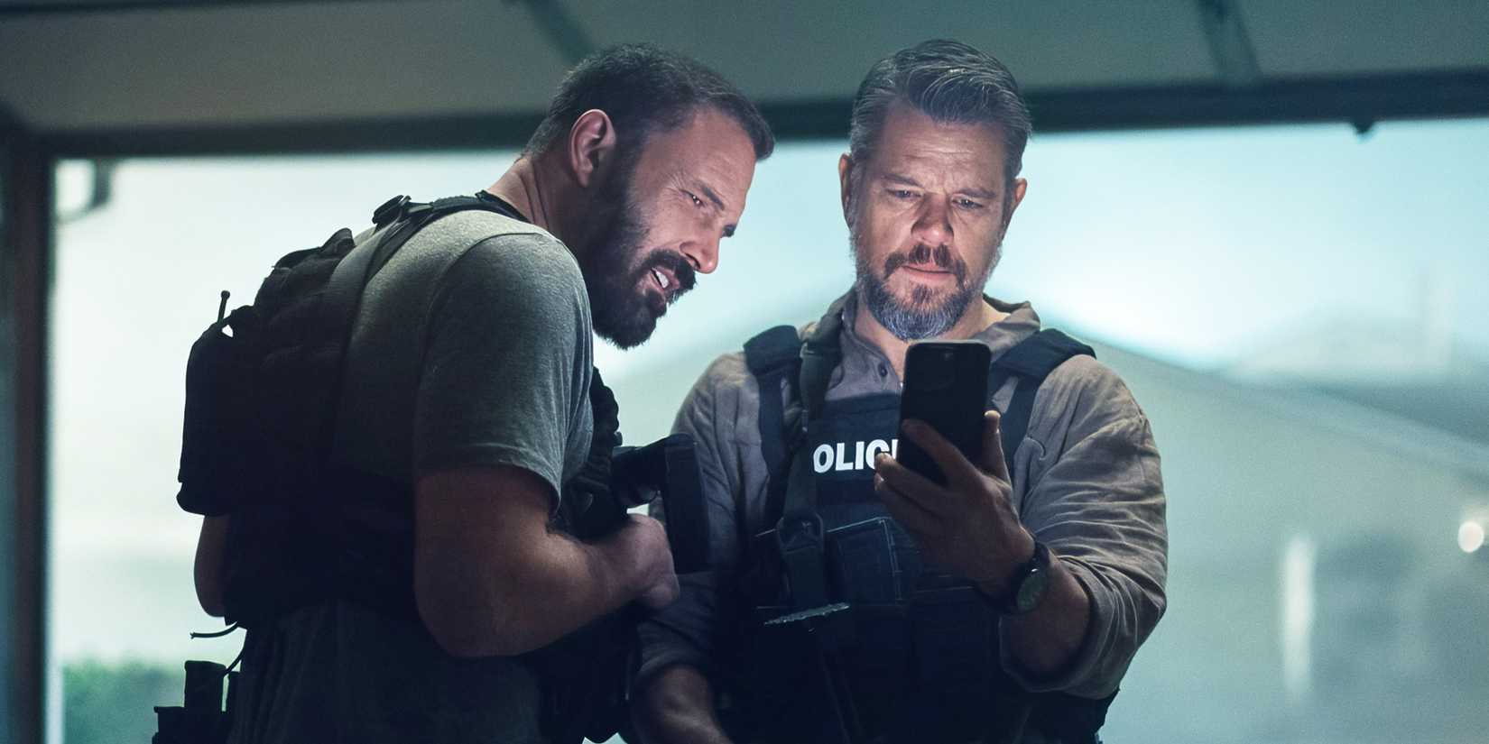  Lieutenant Dane Dumars and Det Sergeant JD Byrne looking at a phone.