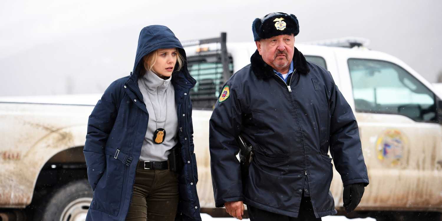 Elizabeth Olsen and Graham Greene walk from a police car to a crime scene in Wind River