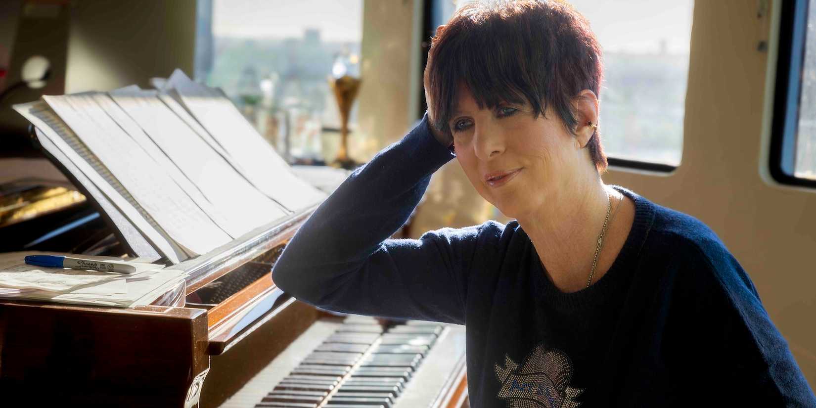 Diane Warren leaning on a piano in Diane Warren: Relentless