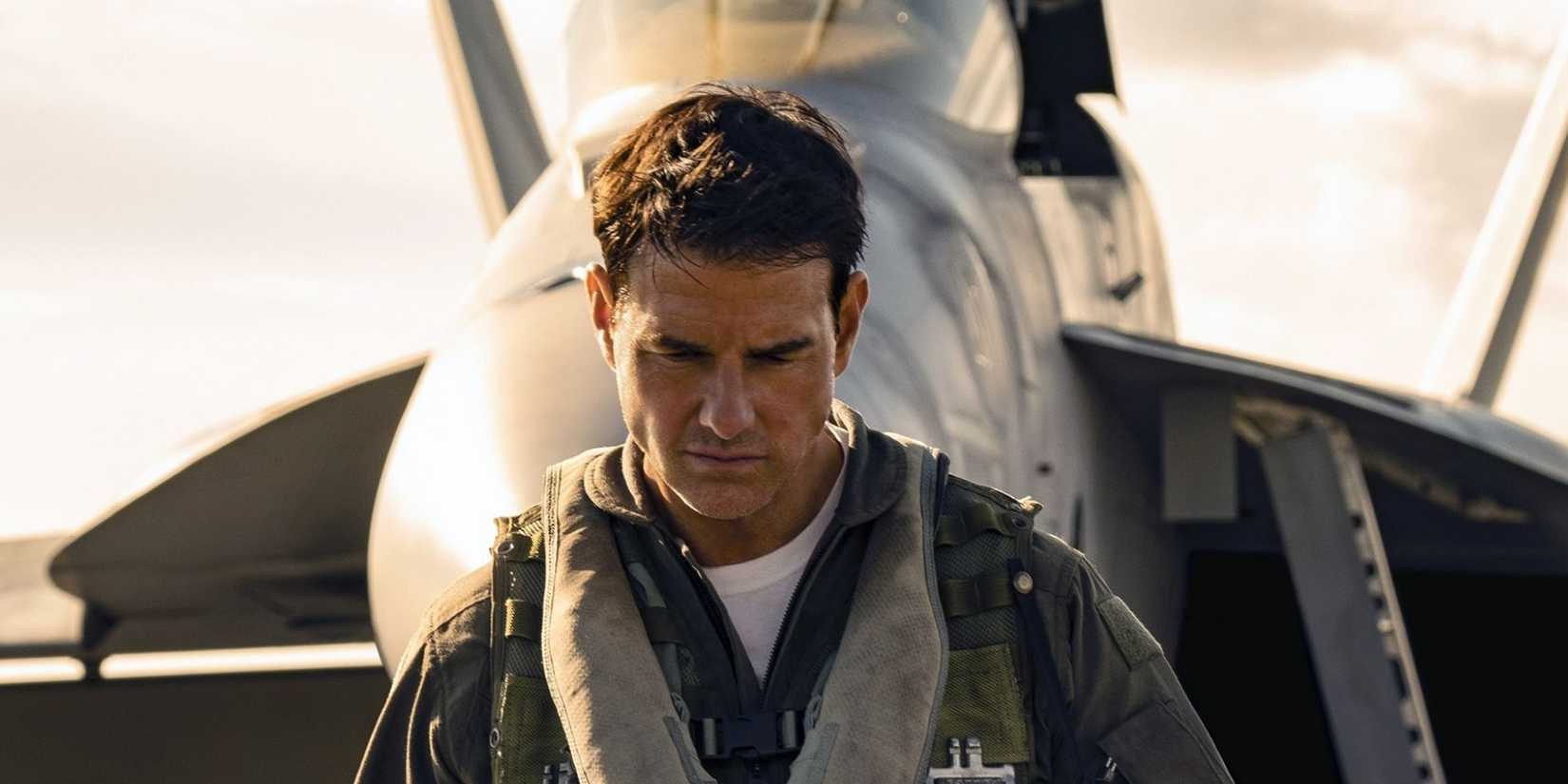 Tom Cruise looking down in front of a fighter jet in Top Gun: Maverick