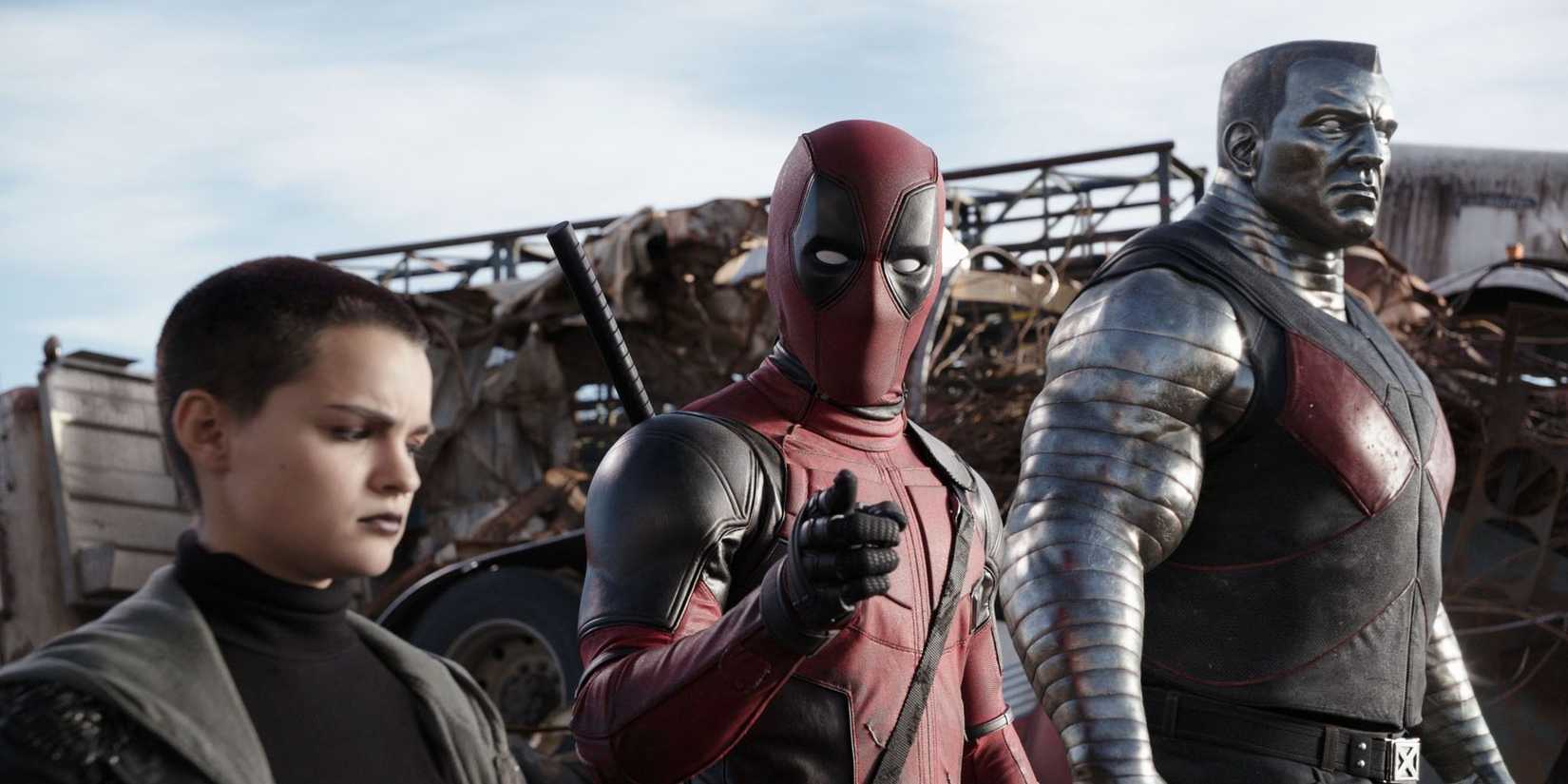 Negasonic Teenage Warhead, Wade Wilson, and Colossus standing in a line, with Wade looking and pointing at the camera, in Deadpool