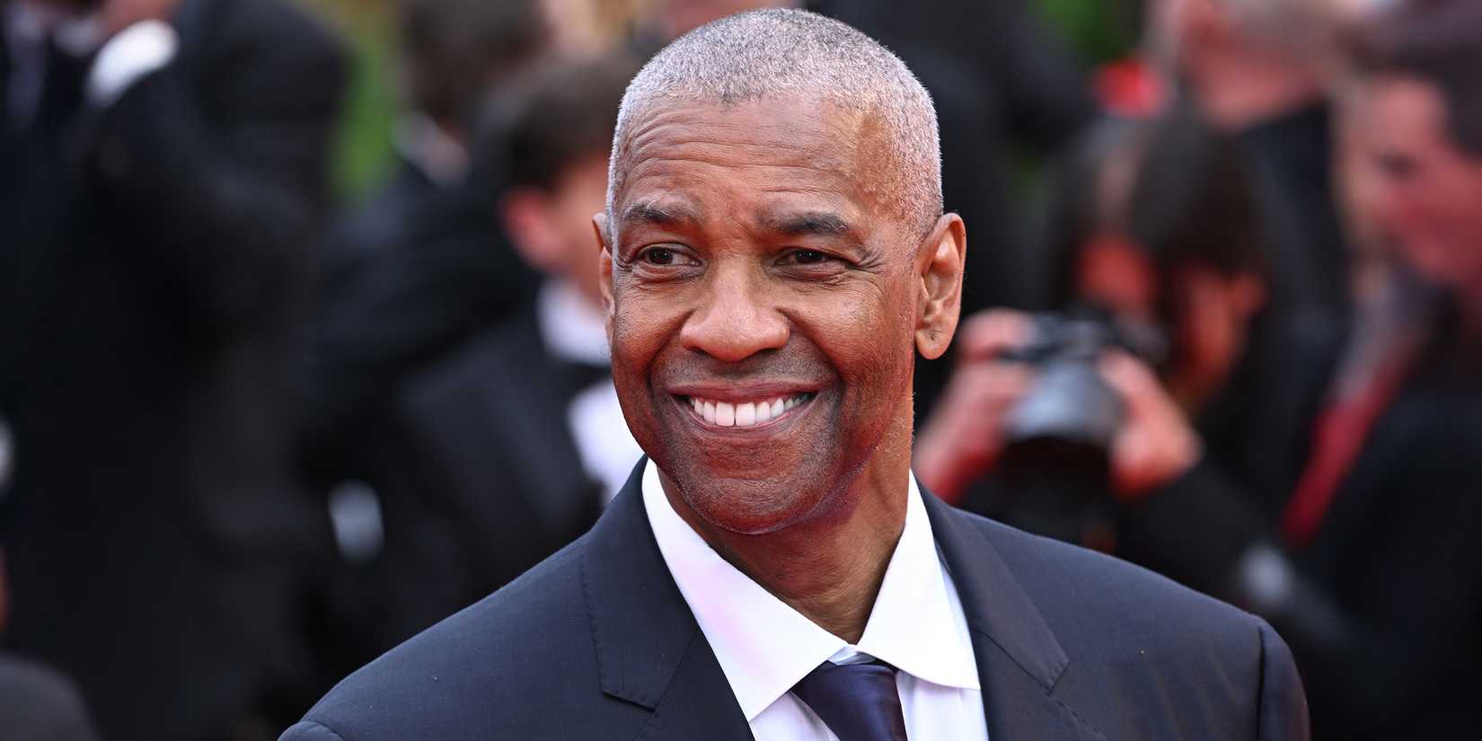 Denzel Washington smiles on the red carpet
