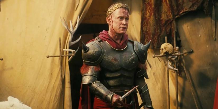 Lacerta standing with a bloody knife and crown on his head in Fallout.