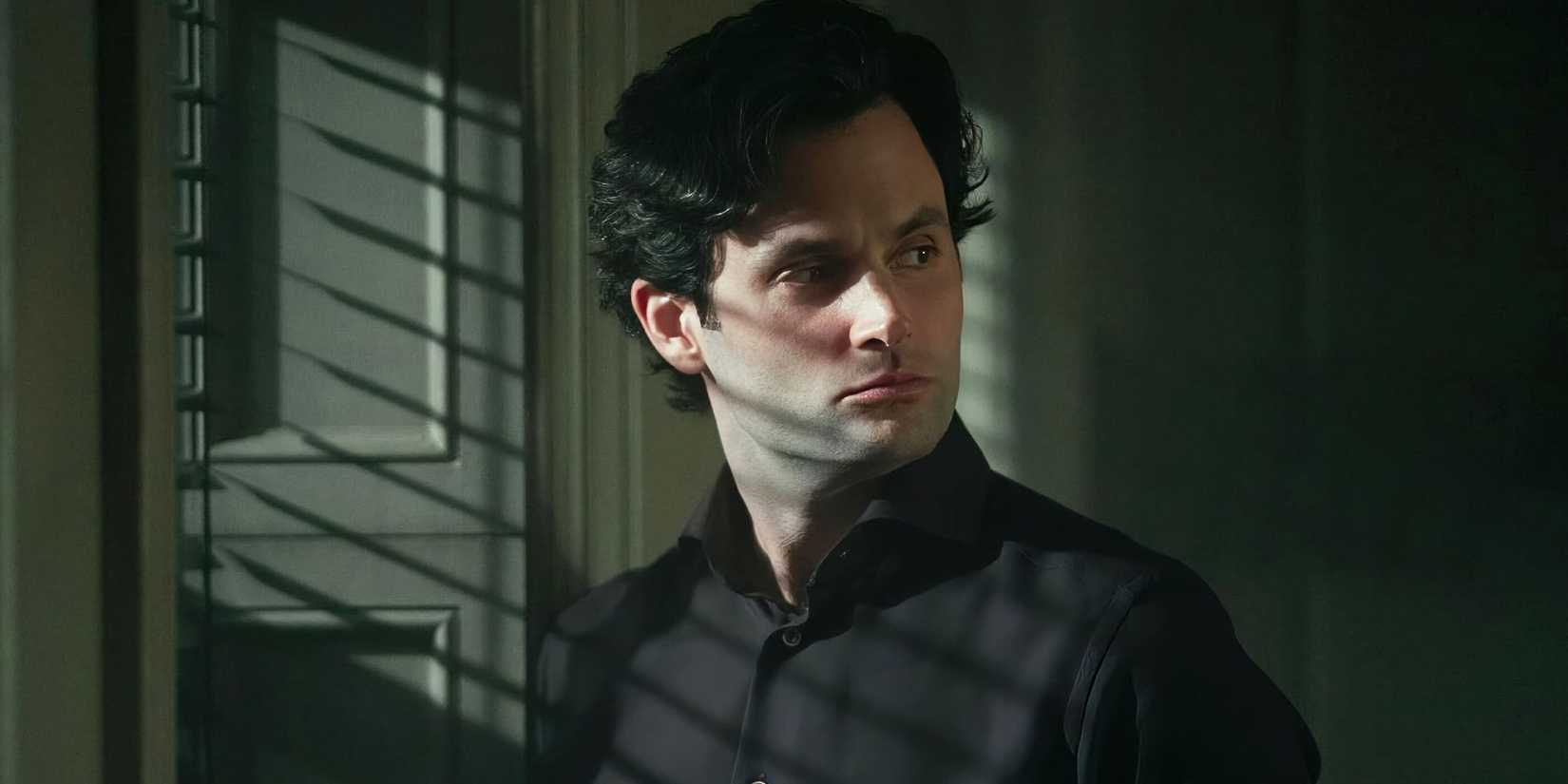 Penn Badgley in You standing by a window