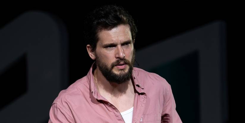 Kit Harington as Sir Henry Muck looking serious in a pink button-down shirt in Industry Season 4