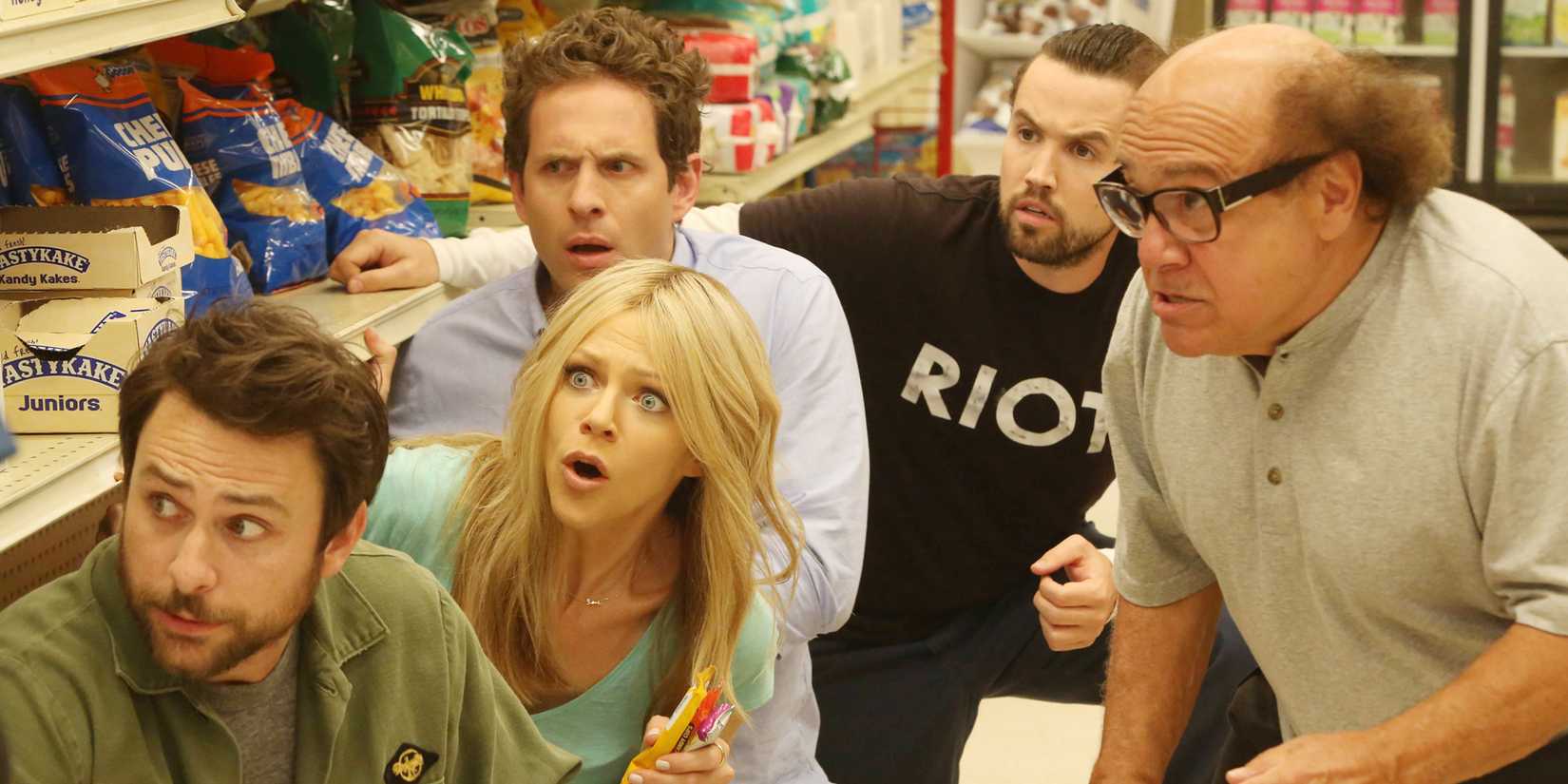 The gang of It's Always Sunny in Philadelphia cowers behind the shelves at a quickmart
