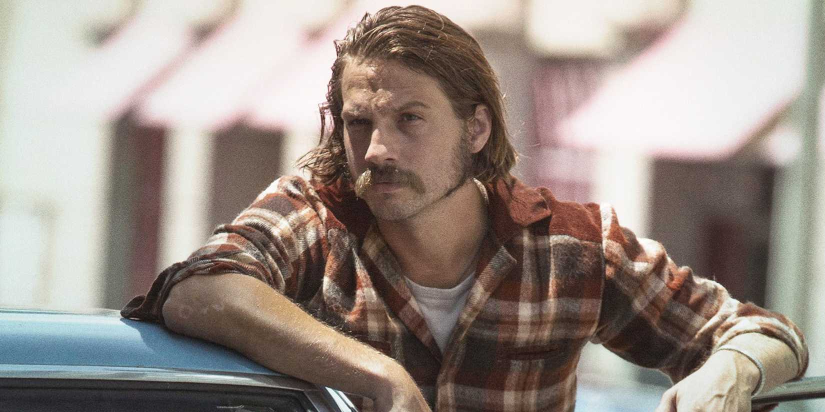 Logan Marshall-Green as Mac leaning his elbow on the top of a car in Quarry