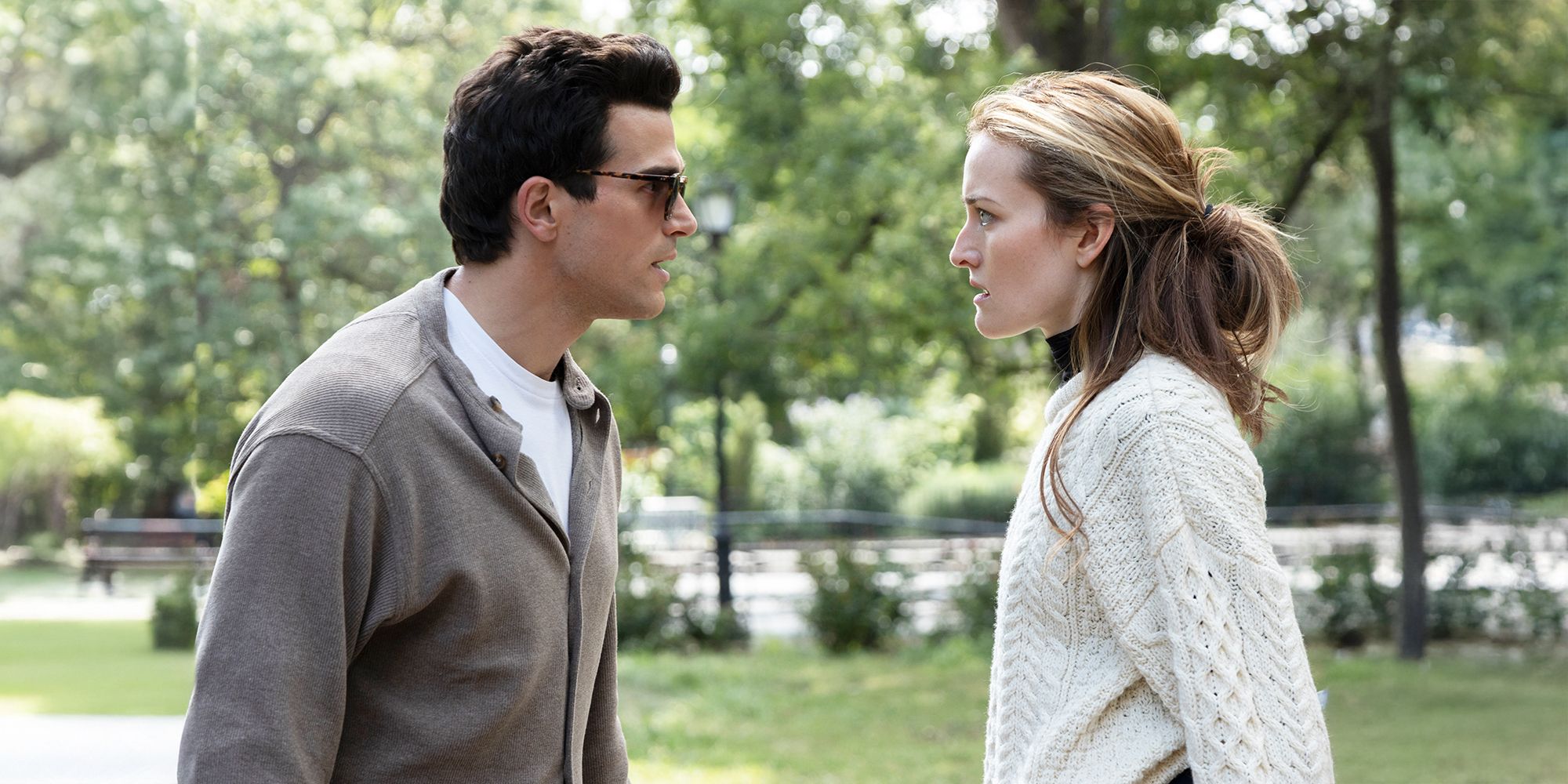 JFK Jr. and Carolyn Bessette facing each other in a park
