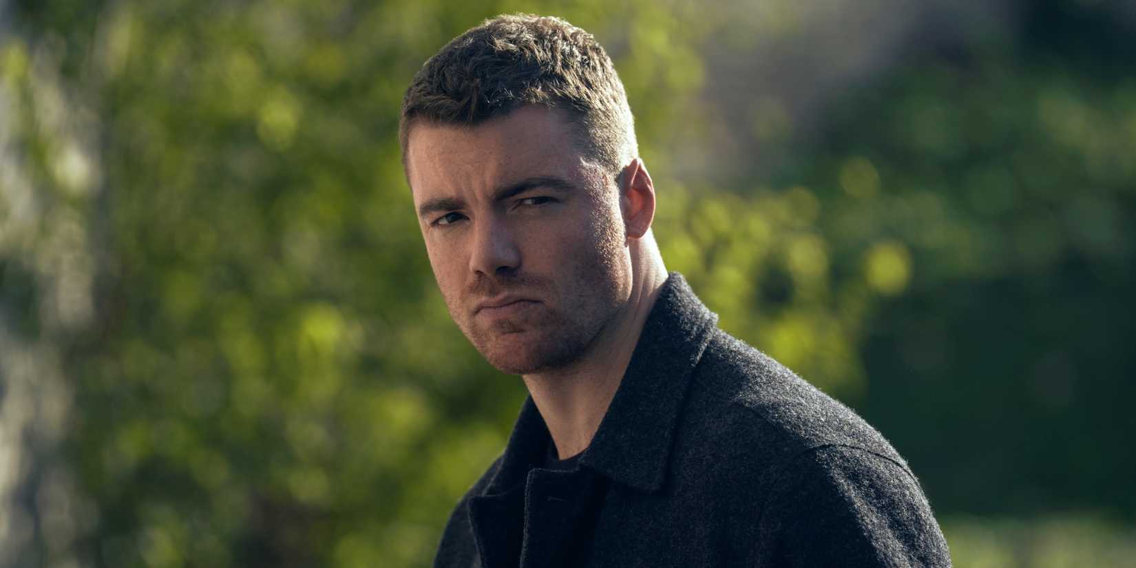 Gabriel Basso as Peter Sutherland looking serious while standing outside in The Night Agent Season 3