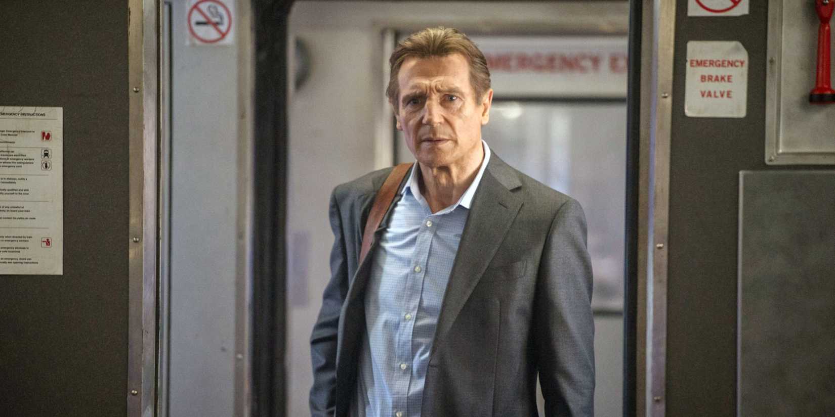 Liam Neeson walking on a train in The Commuter