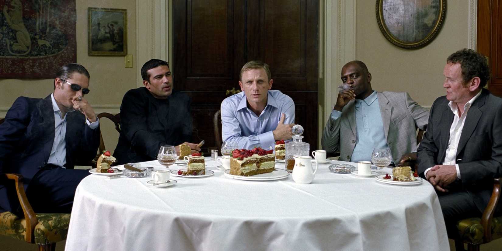 Tom Hardy and Daniel Craig sit at a restaurant table with others in Layer Cake