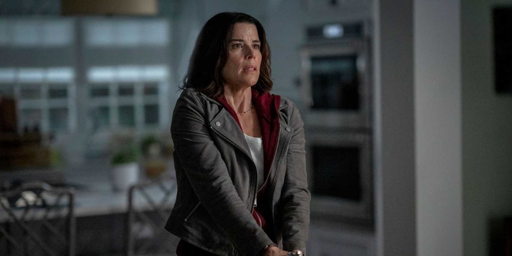 Neve Campbell as Sidney Prescott holds a weapon down in front of her in 'Scream 7'