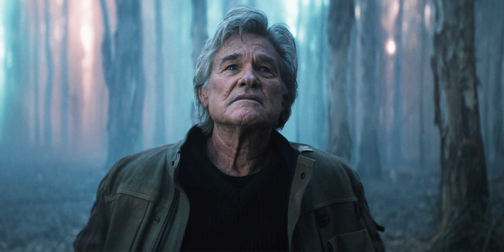 Kurt Russell looking up in the woods