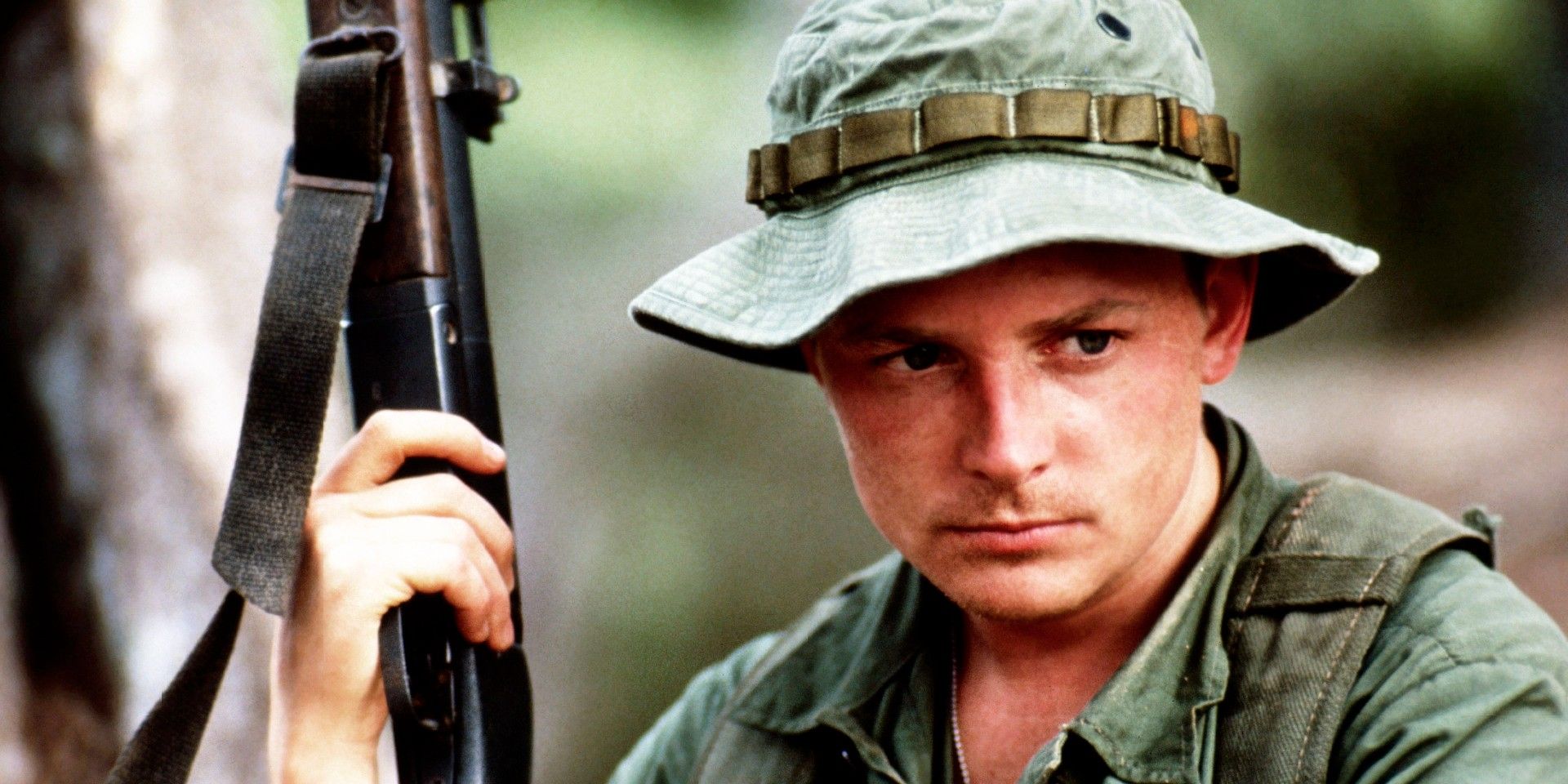Michael J Fox holding a rifle in Casualties of War