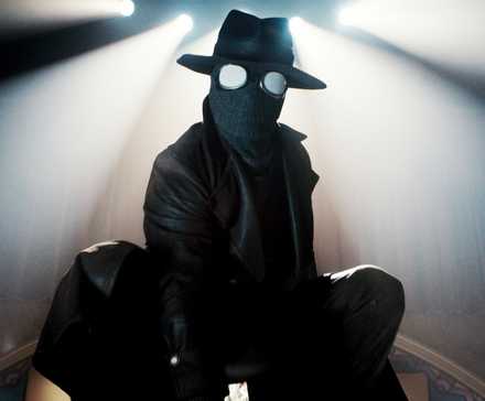 Nicolas Cage crouched on a desk in-costume in Spider-Noir