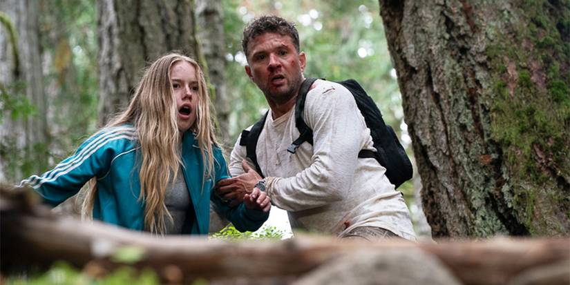 Danny helps Alex down a hill in the forest.