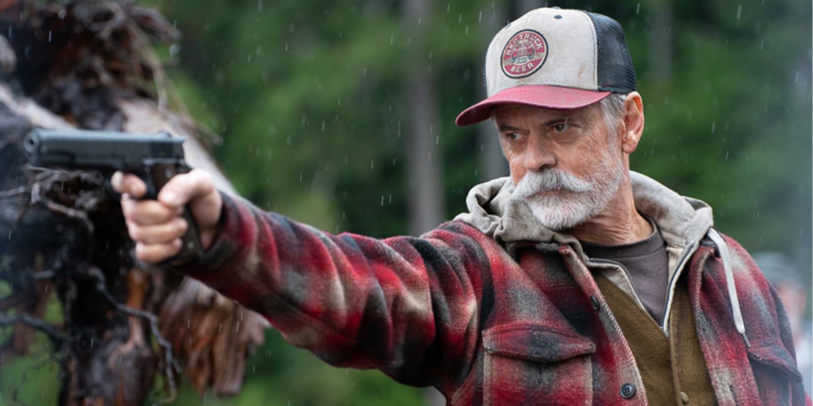 Stanley aims a gun at someone off-camera.