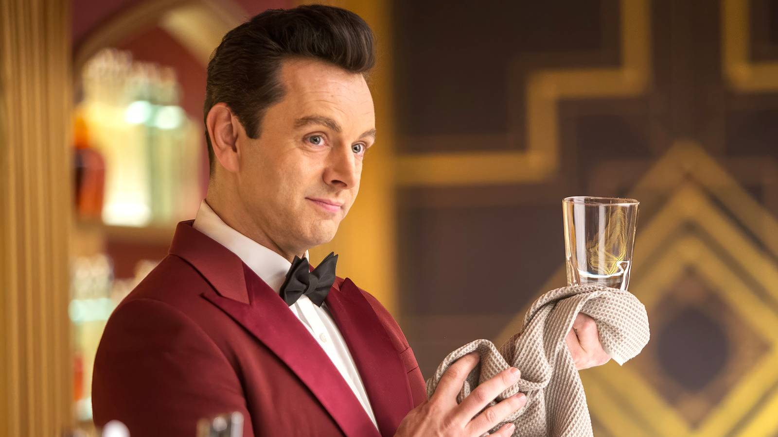 Michael Sheen as a bartender, cleans a glass with a rag in Passengers