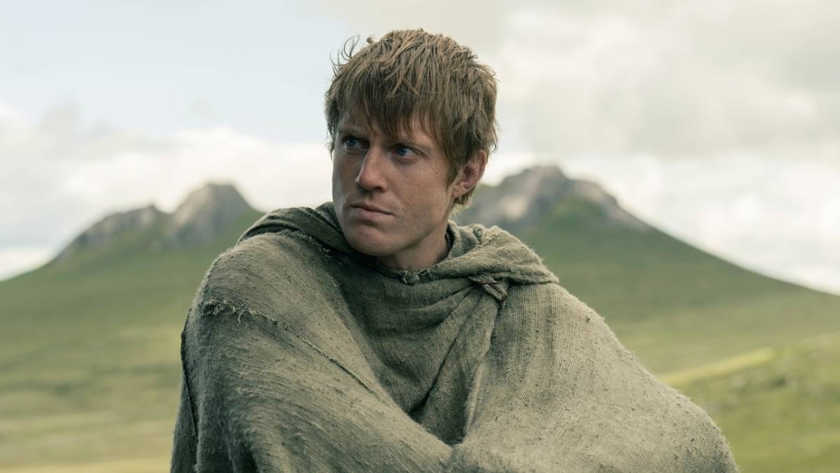 Peter Claffey as Dunk sitting while wearing a poncho and looking right in A Knight of the Seven Kingdoms