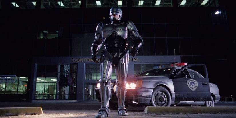 RoboCop (Peter Weller) walks from his police cruiser behind him.