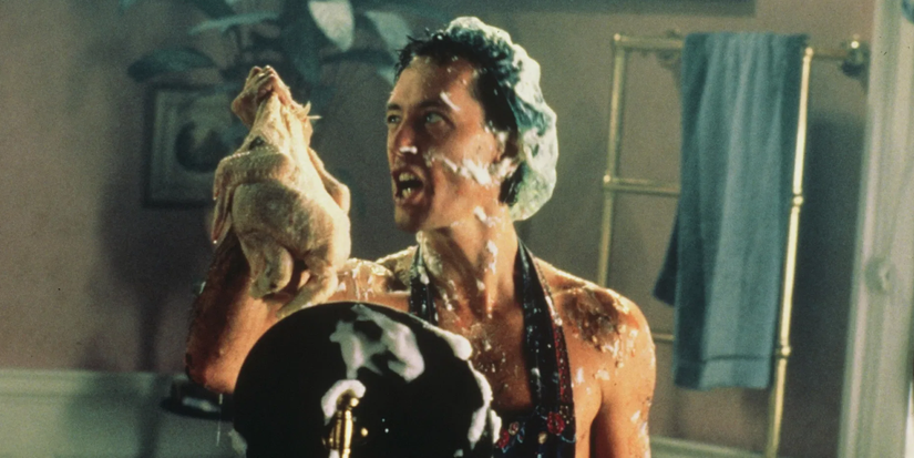 A man covered in shower foam talks angrily to a rabbit doll