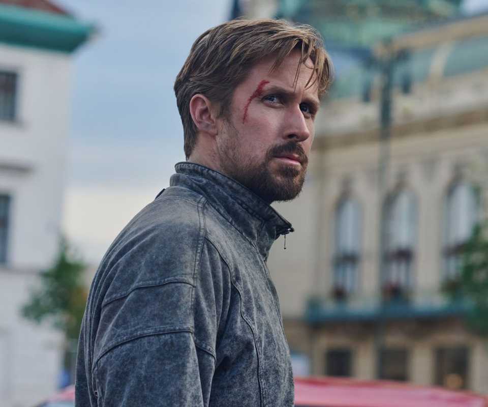 Ryan Gosling with a cut on his face looks over his shoulder in The Gray Man