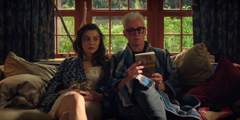 Rachel Weisz sitting on couch with John Slattery in Vladimir