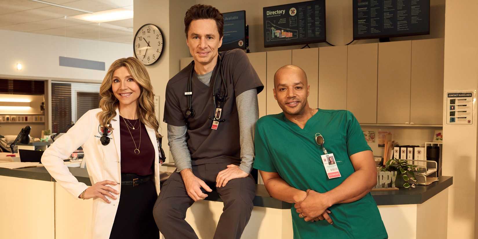 Zach Braff as J.D., Donald Faison as Turk and Sarah Chalke as Elliot posing at the nurse's station in Scrubs