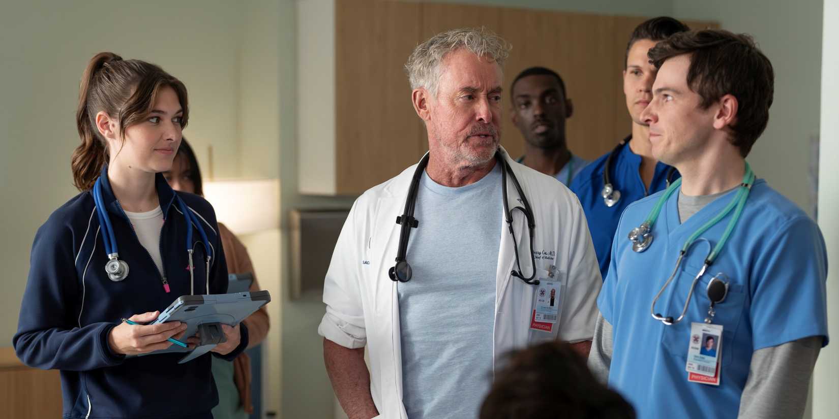 John C. McGinley as Dr. Cox standing with four Sacred Heart interns in the Scrubs revival