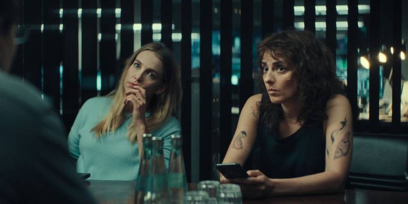 Susanne Wolff and Seyneb Salah sit at a table filled with water and glasses in Unfamiliar