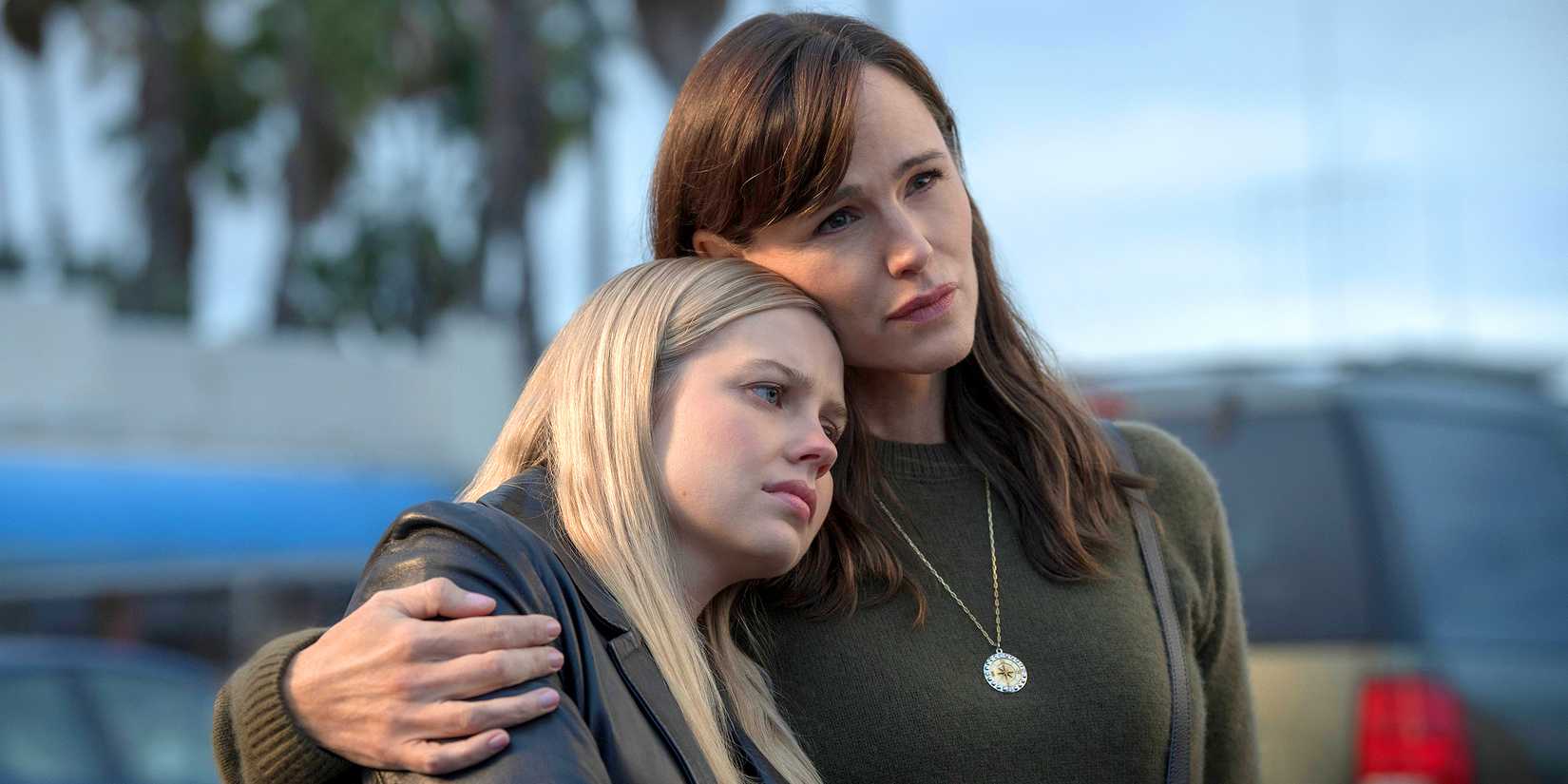 Jennifer Garner wears a green long sleeve shirt and puts her arm around Angourie Rice in 'The Last Thing He Told Me'